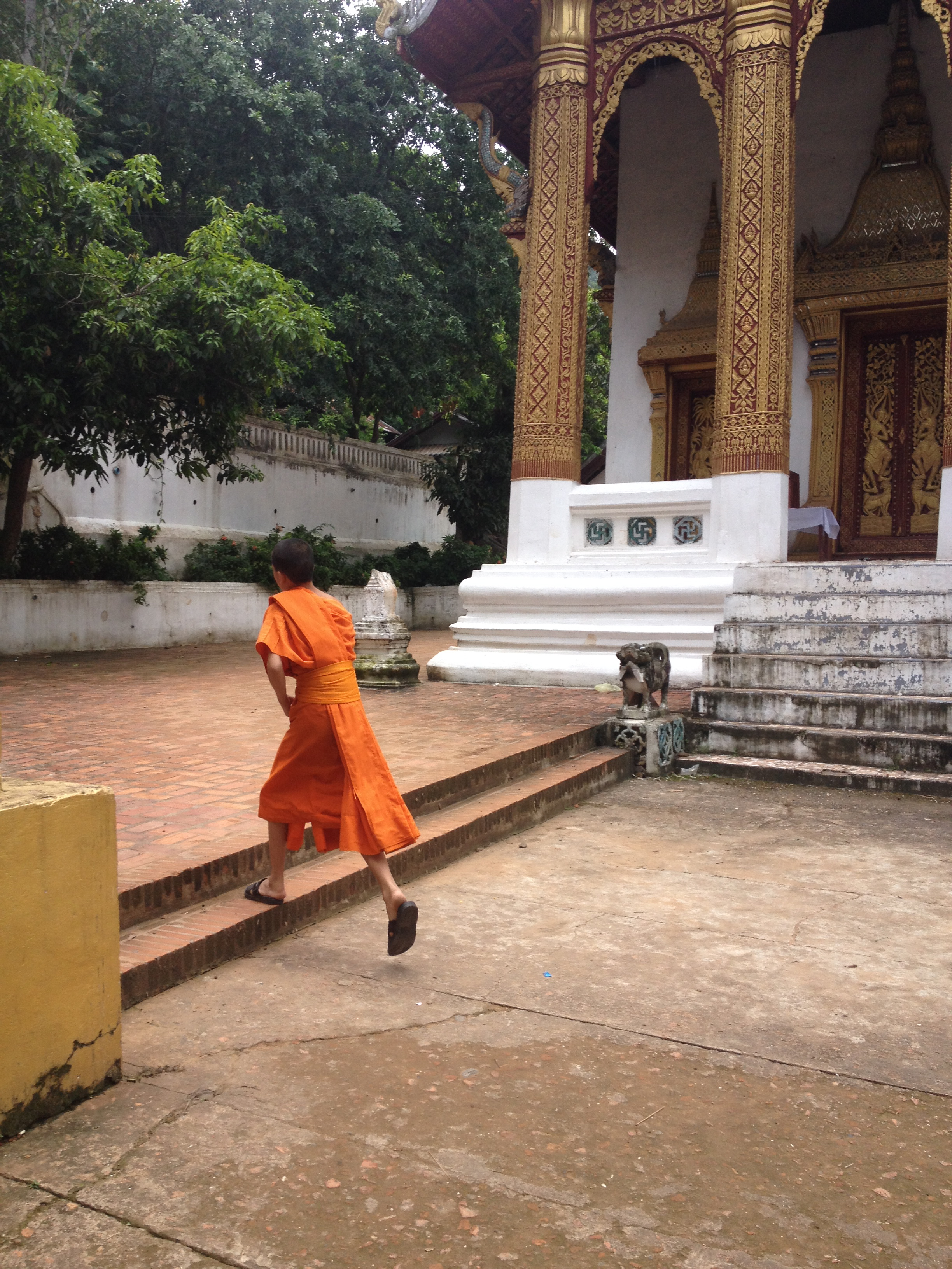 Photo d'un petit moine boudhiste courrant.